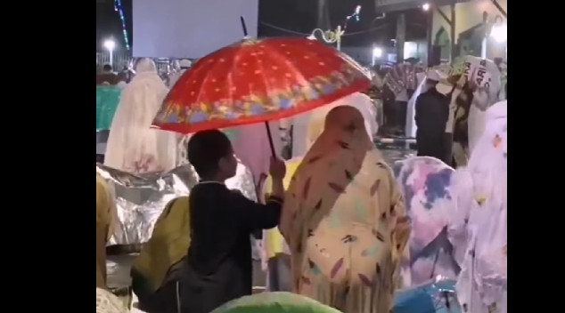 Dobročinstvo prema majci: Dok klanja, sin joj drži kišobran (VIDEO)